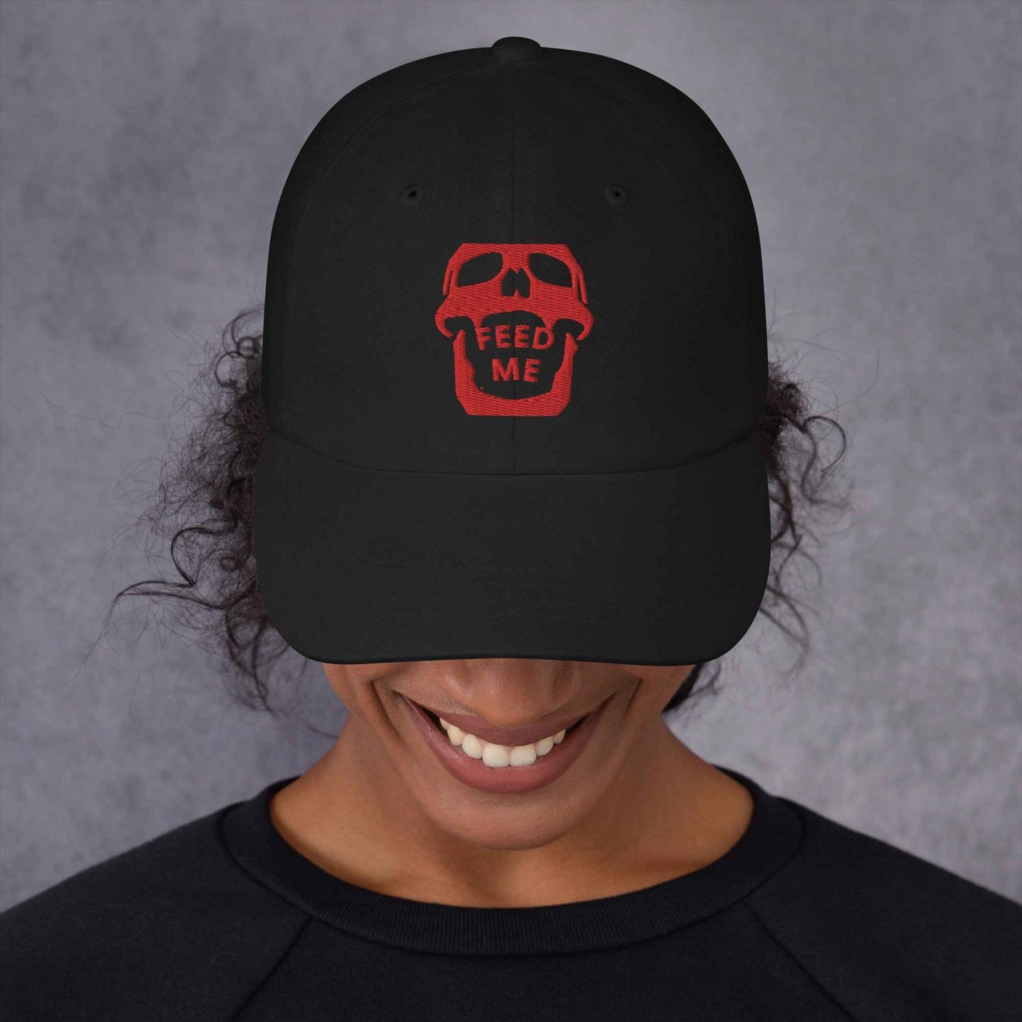 Feed Me Skull dad hat by Appetite Apparel with a cartoon skull and fun foodie illustrations on a casual, adjustable cap.