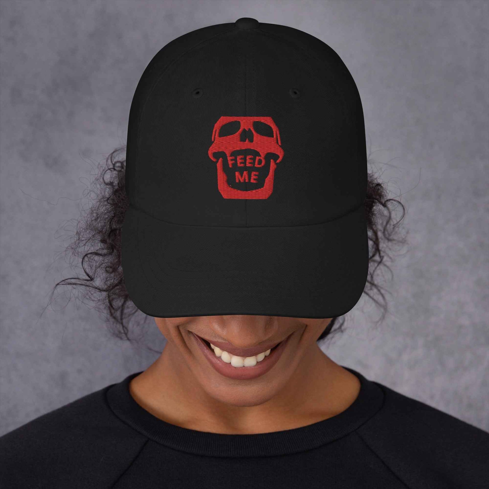 Feed Me Skull dad hat by Appetite Apparel with a cartoon skull and fun foodie illustrations on a casual, adjustable cap.