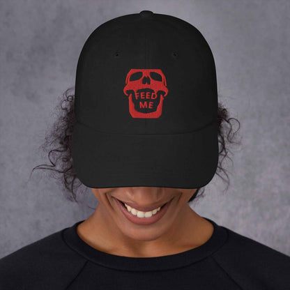 Feed Me Skull dad hat by Appetite Apparel with a cartoon skull and fun foodie illustrations on a casual, adjustable cap.