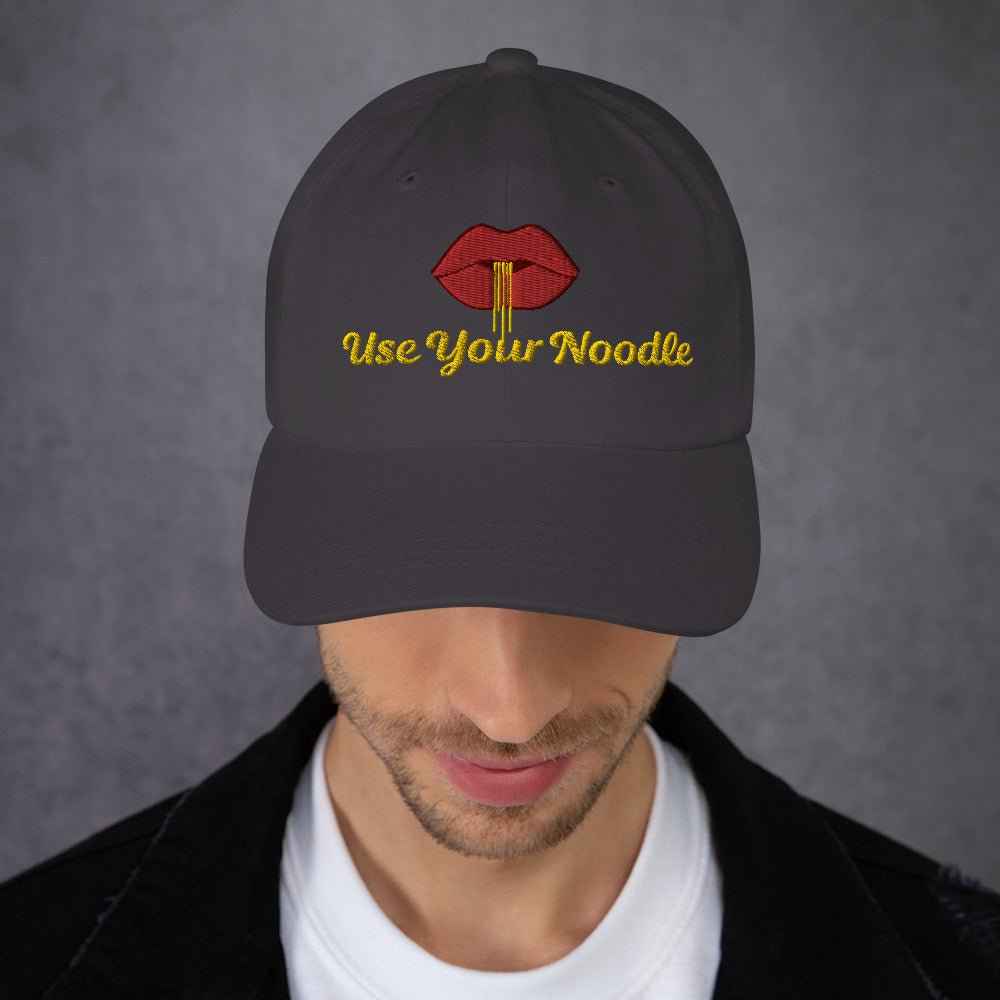 Dark grey Use Your Noodle Dad Hat by Appetite Apparel featuring a Noggin or Knob design in a casual, adjustable style.