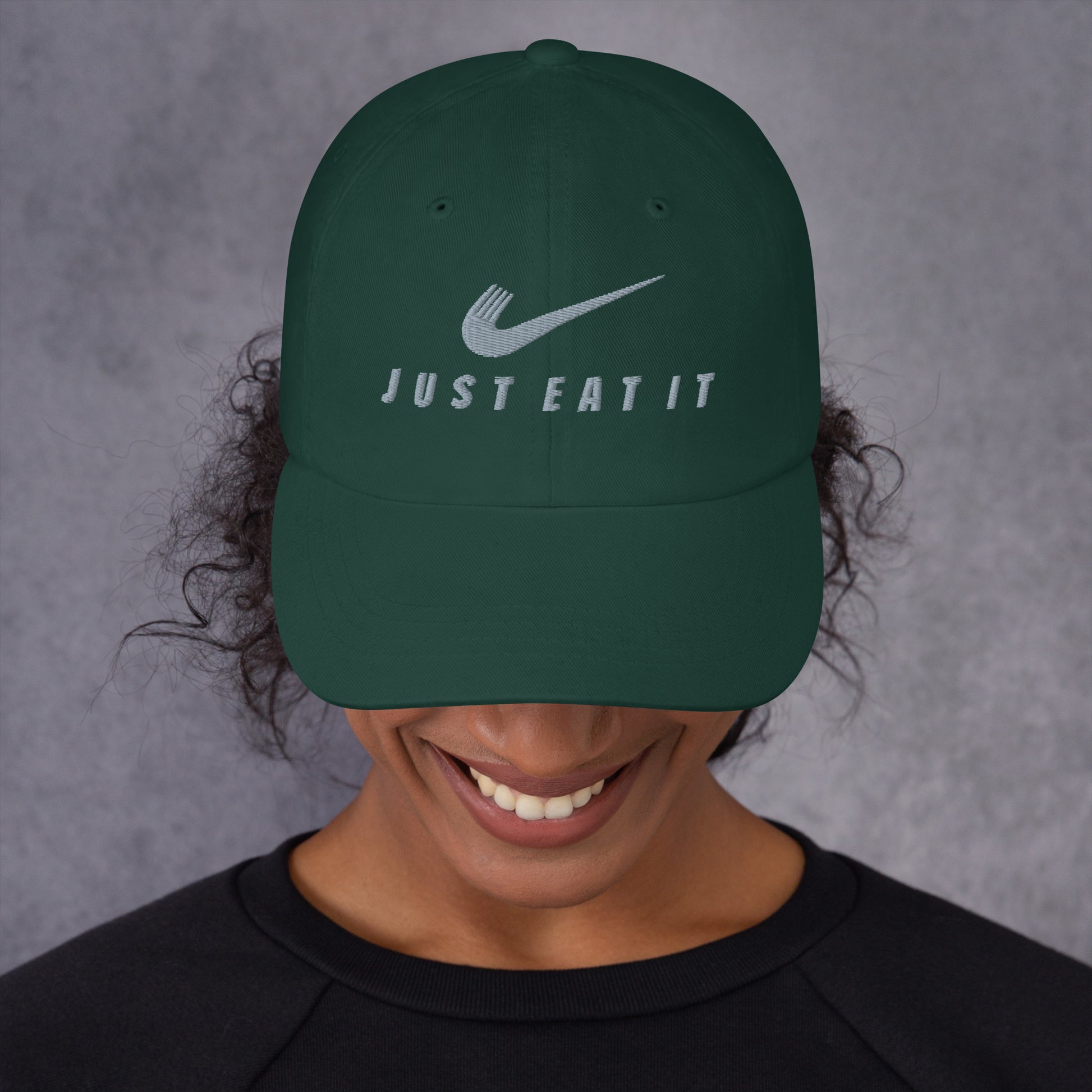 Classic spruce-colored dad hat with a Nike parody logo and "Just Eat It Dad Hat" embroidered on front by Appetite Apparel.
